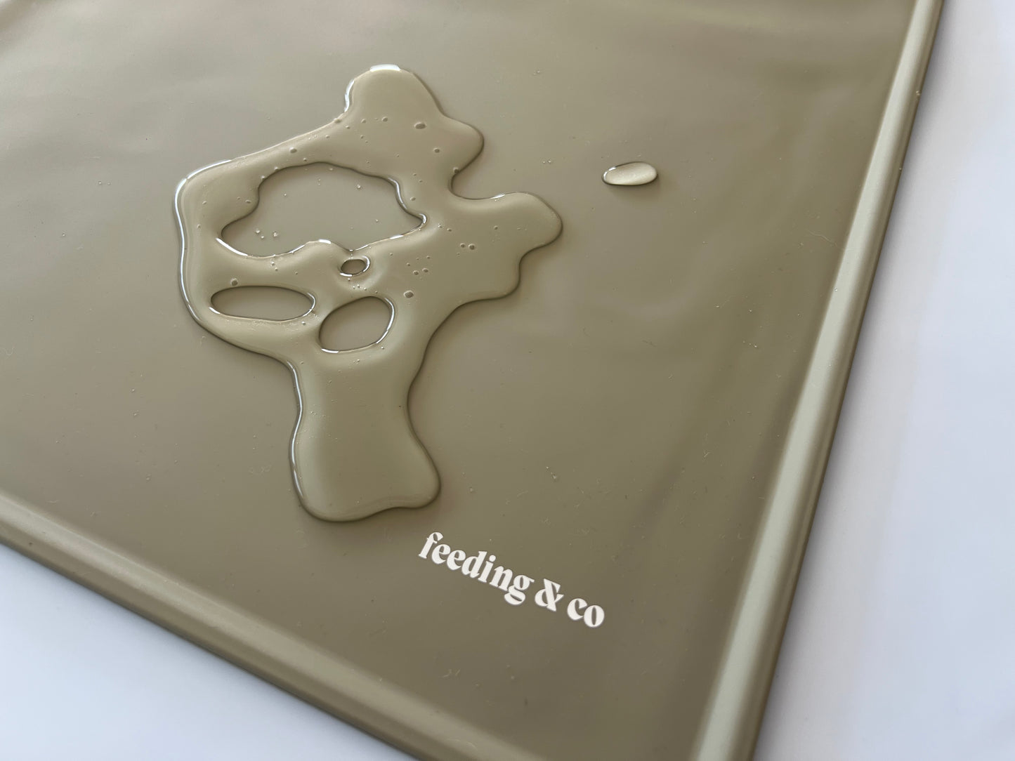 Olive silicone mat with a unique design and 'feeding & co' branding on a white background.